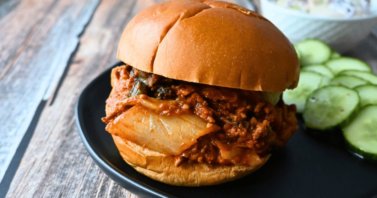 Sloppy Joe kimchi on a bun with a side of marinated pickles