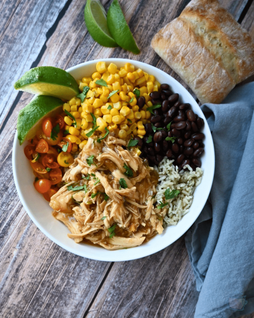 a bowl with maple lime chicken, rice, beans, corn and tomatoes