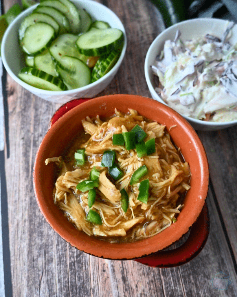 a bowl of maple lime chicken topped with sliced green onion and side dishes