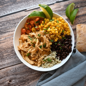 a bowl with maple lime chicken, rice, beans, corn and tomatoes
