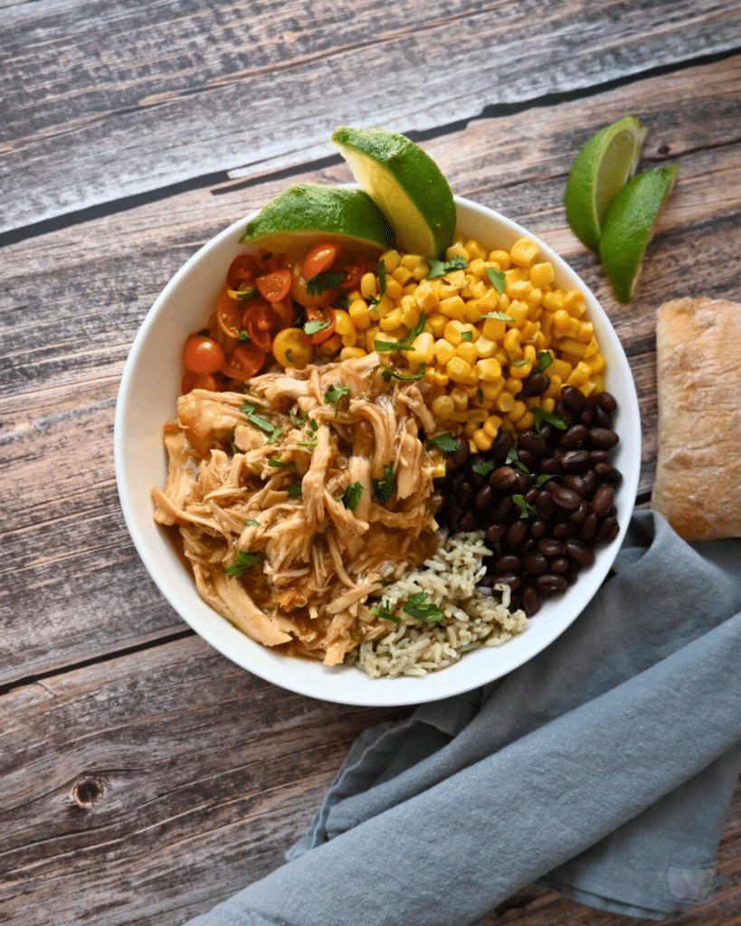 a bowl with maple lime chicken, rice, beans, corn and tomatoes