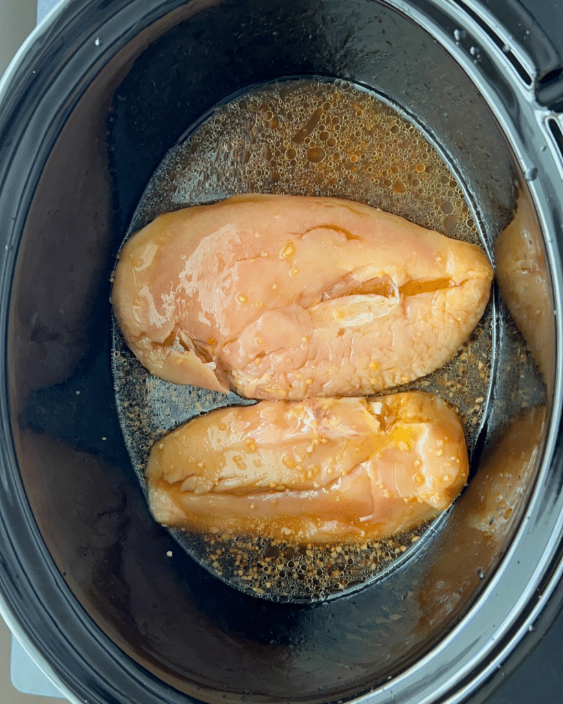 chicken breasts and other sauce ingredients in slow cooker
