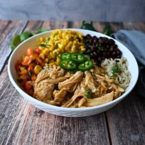 a bowl with maple lime chicken, rice, beans, corn and tomatoes