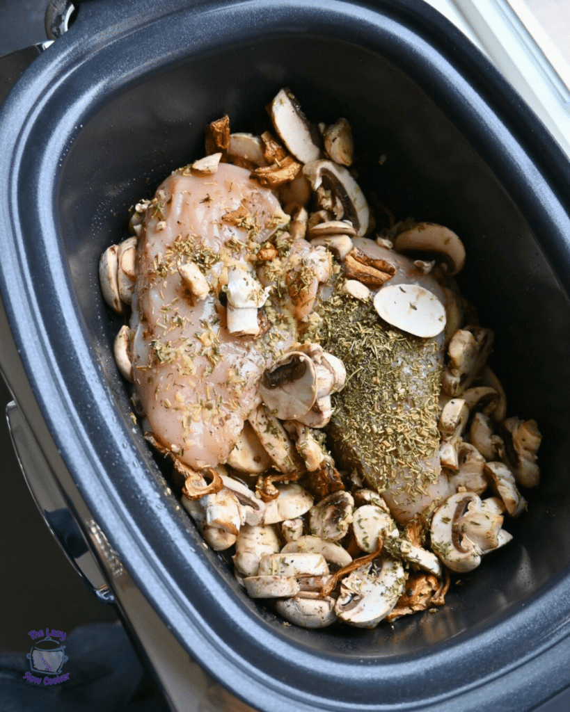cooked chicken, mushrooms and flavoring in a slow cooker