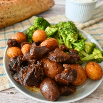 slow cooker bbq steak bites and potatoes on a plate with broccoli