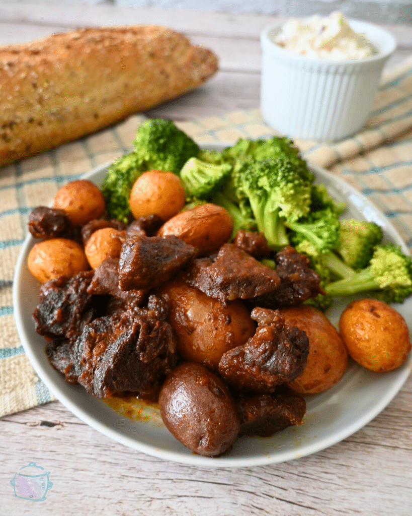 slow cooker bbq steak bites and potatoes on a plate with broccoli