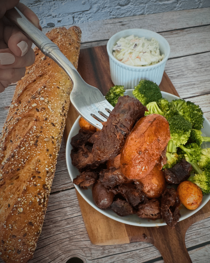 slow cooker bbq steak bites and potatoes on a plate with broccoli
