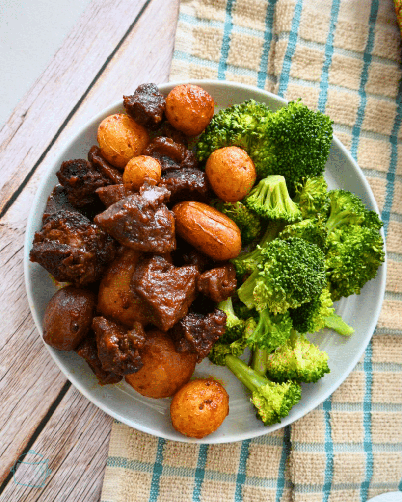 slow cooker bbq steak bites and potatoes on a plate with broccoli