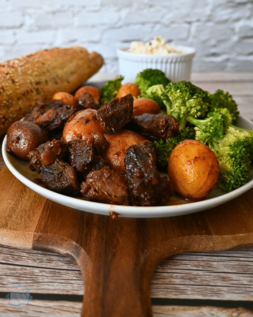 slow cooker bbq steak bites and potatoes on a plate with broccoli