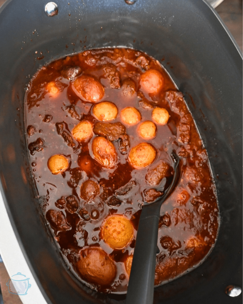 steak bites and potatoes bbq sauce in a slow cooker after cooking