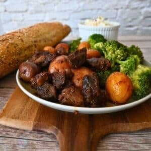 slow cooker bbq steak bites and potatoes on a plate with broccoli