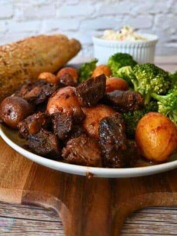 slow cooker bbq steak bites and potatoes on a plate with broccoli