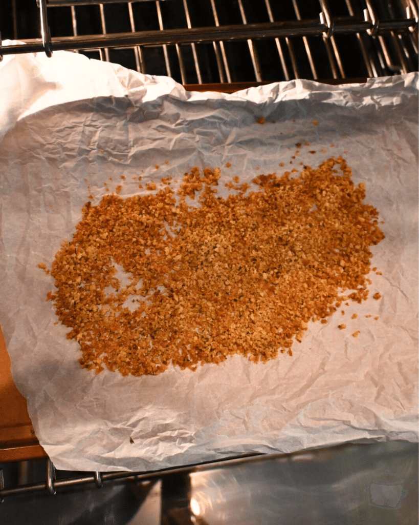 toasted panko crumbs on a baking sheet outside an over door