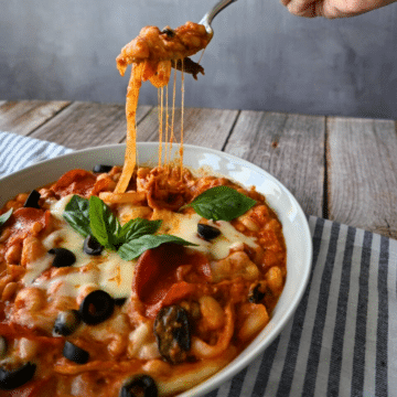 A bowl of pizza beans ready to be eaten with some on a fork
