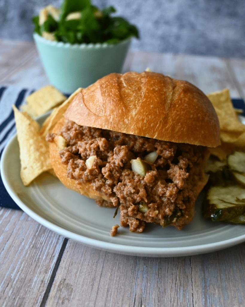 close up of a slow cooker dill pickle sloppy Joe sandwich with chips