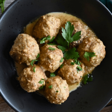 air fryer meatballs in tahini sauce in a black bowl