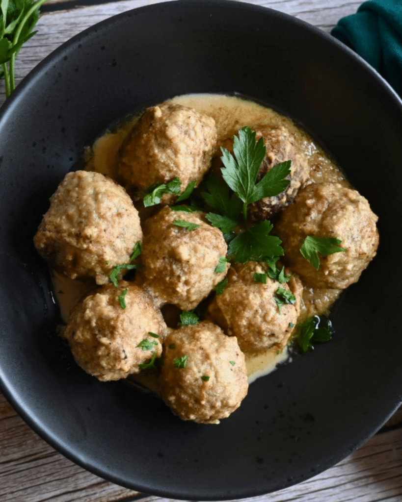 air fryer meatballs in tahini sauce in a black bowl