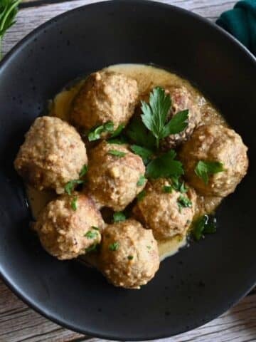 air fryer meatballs in tahini sauce in a black bowl