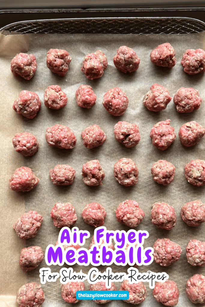 raw meatballs lined up on a an air fryer cooking tray
