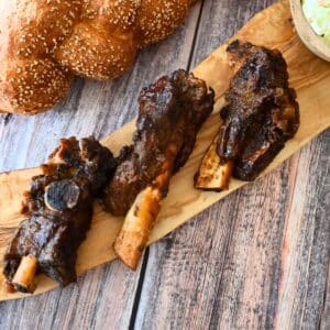 three ribs on a wooden serving tray