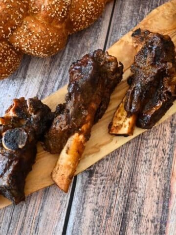 three ribs on a wooden serving tray