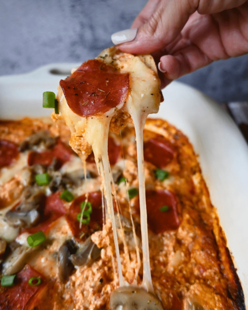 Gooey cheesy slow cooker cottage cheese pizza dip on a cracker
