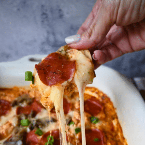 Gooey cheesy slow cooker cottage cheese pizza dip on a cracker