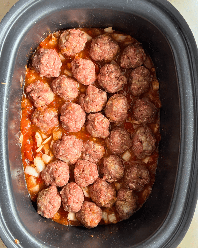 meatballs sitting in sauce in a slow cooker