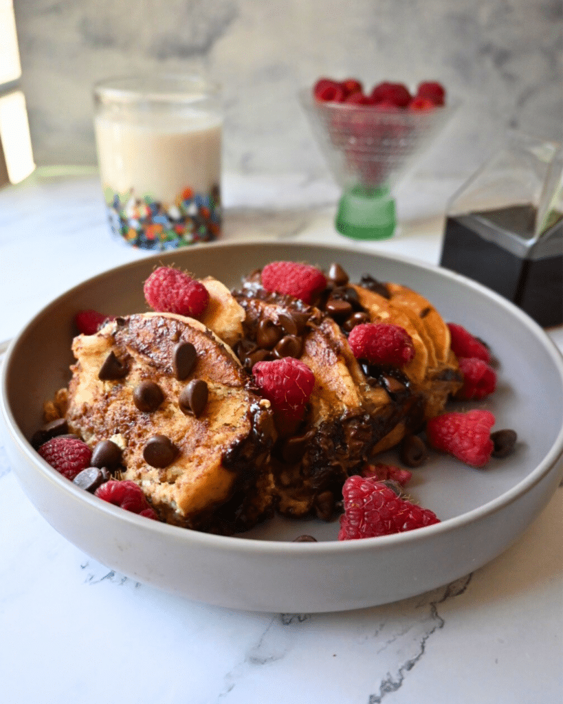 a bowl full of slow cooker chocolate chip pancake casserole topped with berries
