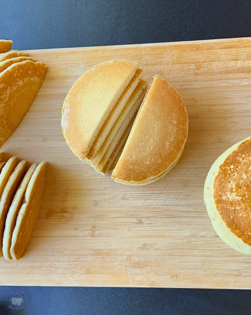 pancakes on a cutting board cut in half