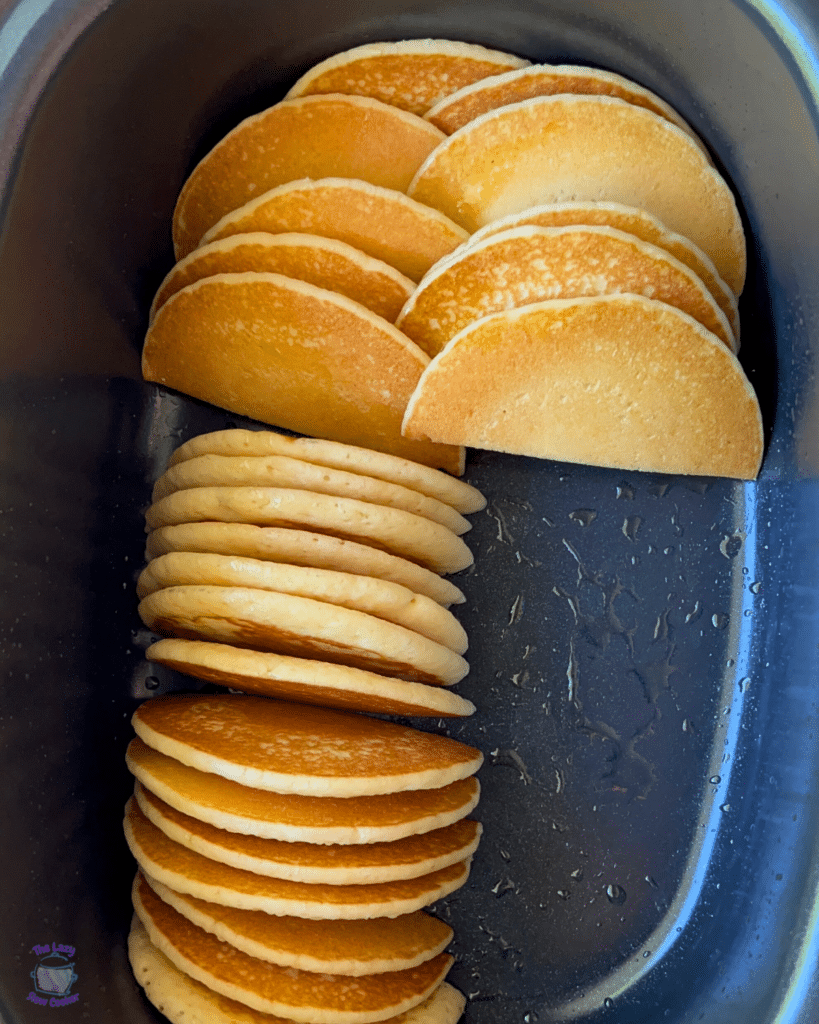 pancakes cut in half in a greased slow cooker