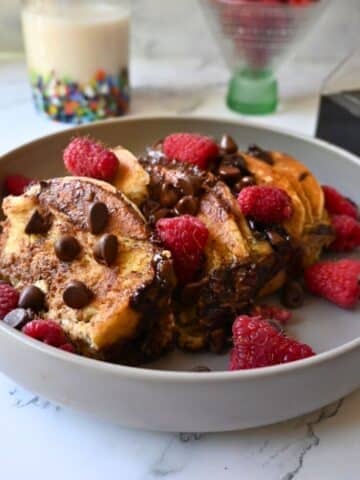 a bowl full of slow cooker chocolate chip pancake casserole topped with berries