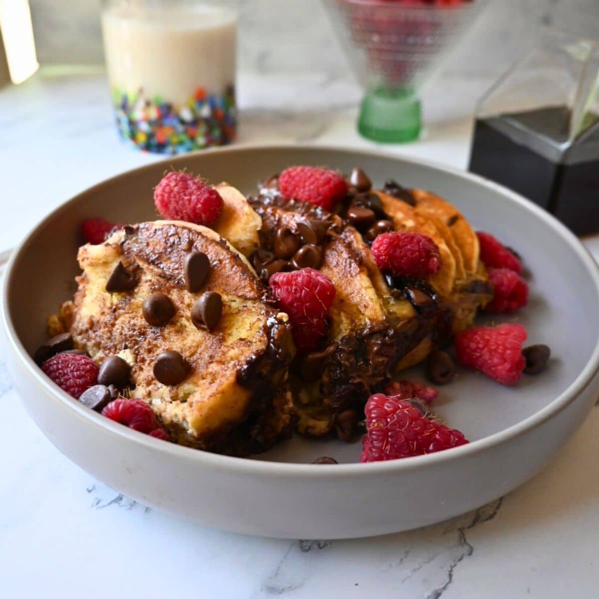 a bowl full of slow cooker chocolate chip pancake casserole topped with berries