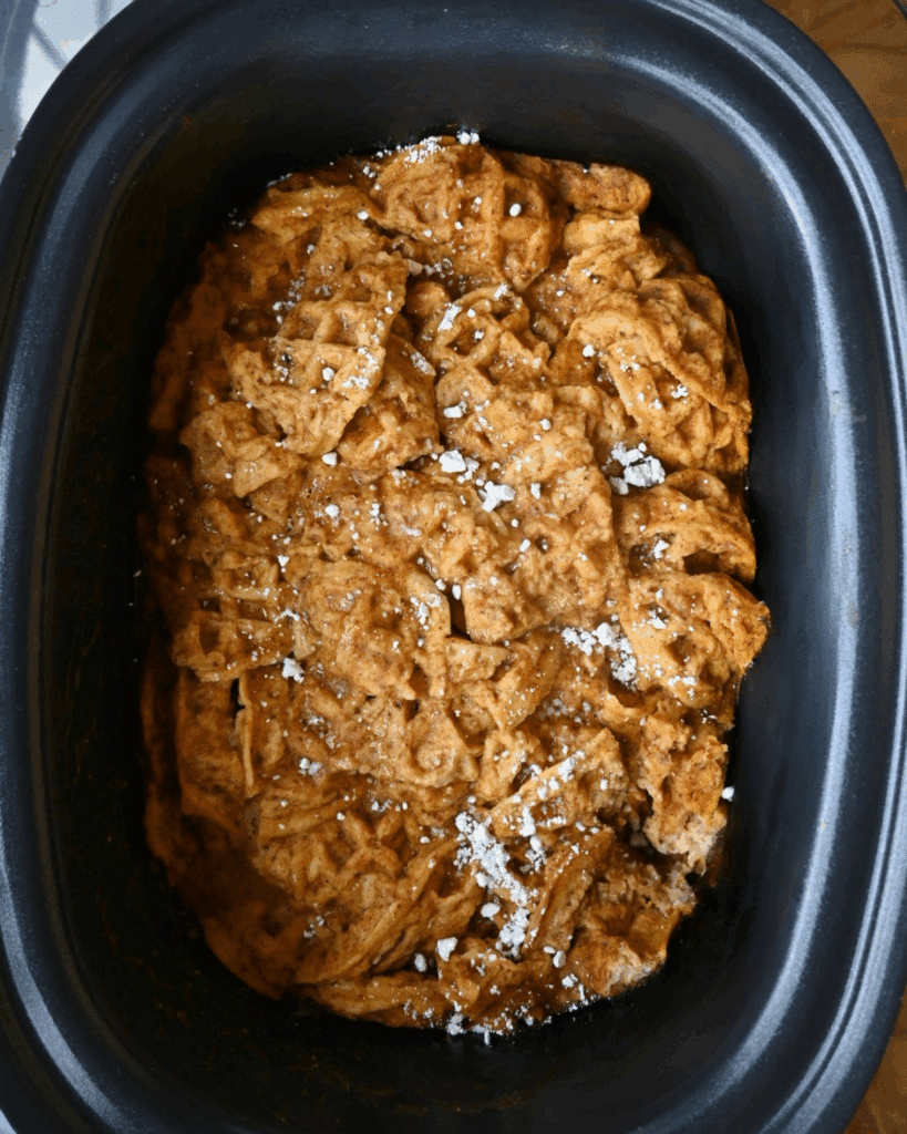 a slow cooker full of pumpkin waffle casserole ready to serve