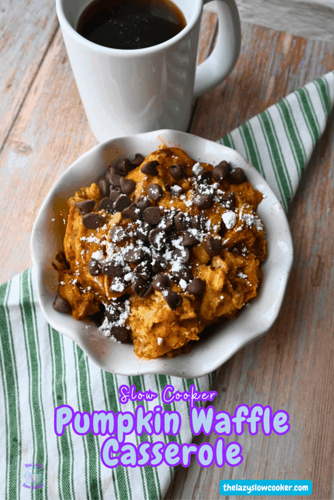 A bowl full of slow cooker pumpkin waffle casserole topped with powdered sugar and chocolate chip