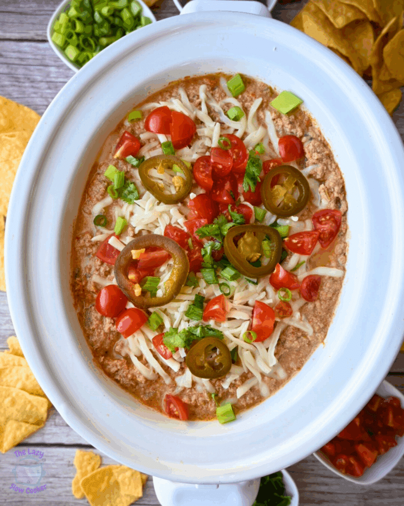 A crockpot full of cottage cheese taco dip with toppings