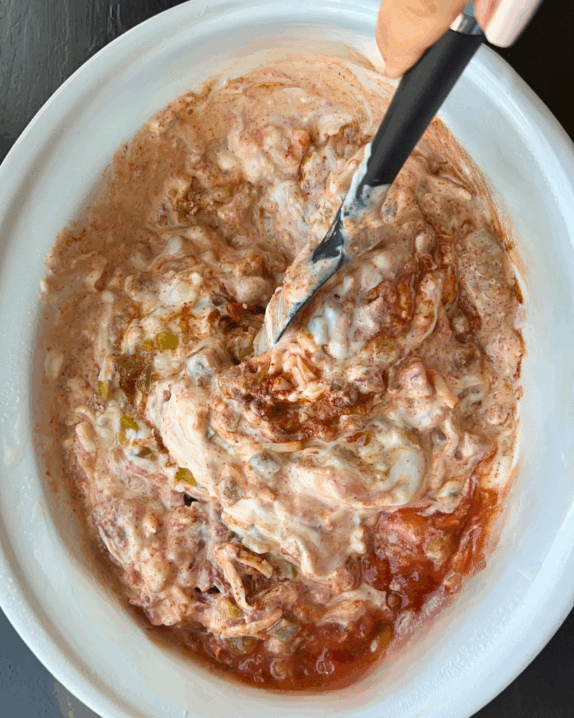 ingredients being stirred in slow cooker for cottage cheese taco dip, before cooking