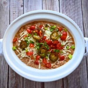 A crockpot full of cottage cheese taco dip with toppings
