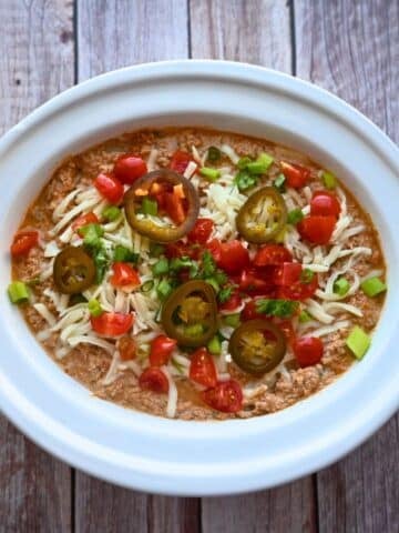 A crockpot full of cottage cheese taco dip with toppings