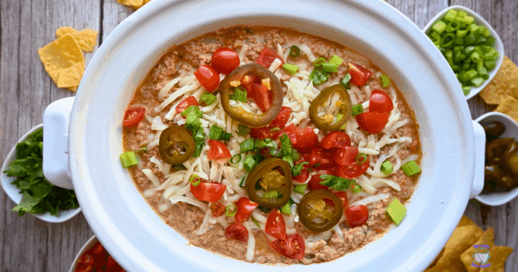 A crockpot full of cottage cheese taco dip with toppings