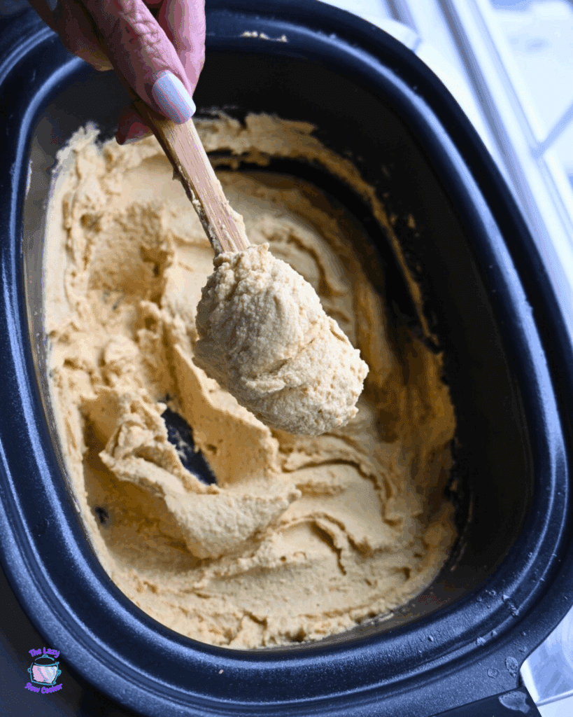 creamy hummus recipe on a spatula over a crockpot