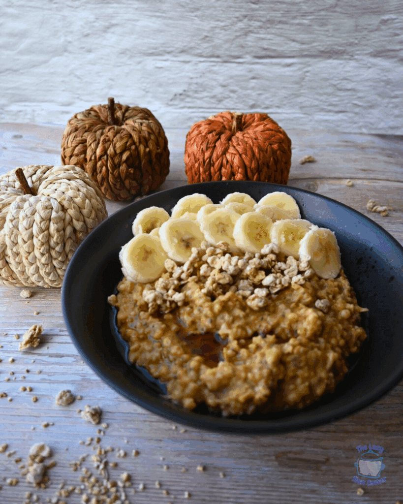 pumpkin oatmeal in a bowl topped with granola and bananas