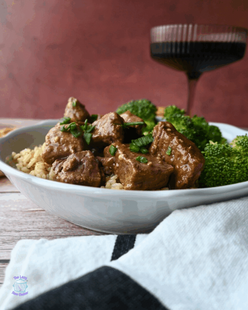 slow cooker steak bites with broccoli on a bed a rice