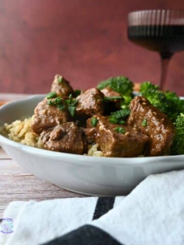 slow cooker steak bites with broccoli on a bed a rice