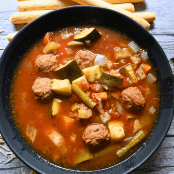 a bowlful of vegetable soup with meatballs made in a slow cooker