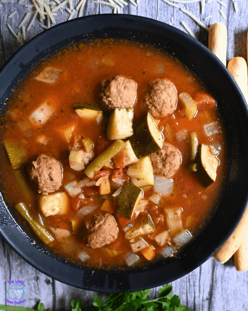 a bowlful of vegetable soup with meatballs made in a slow cooker