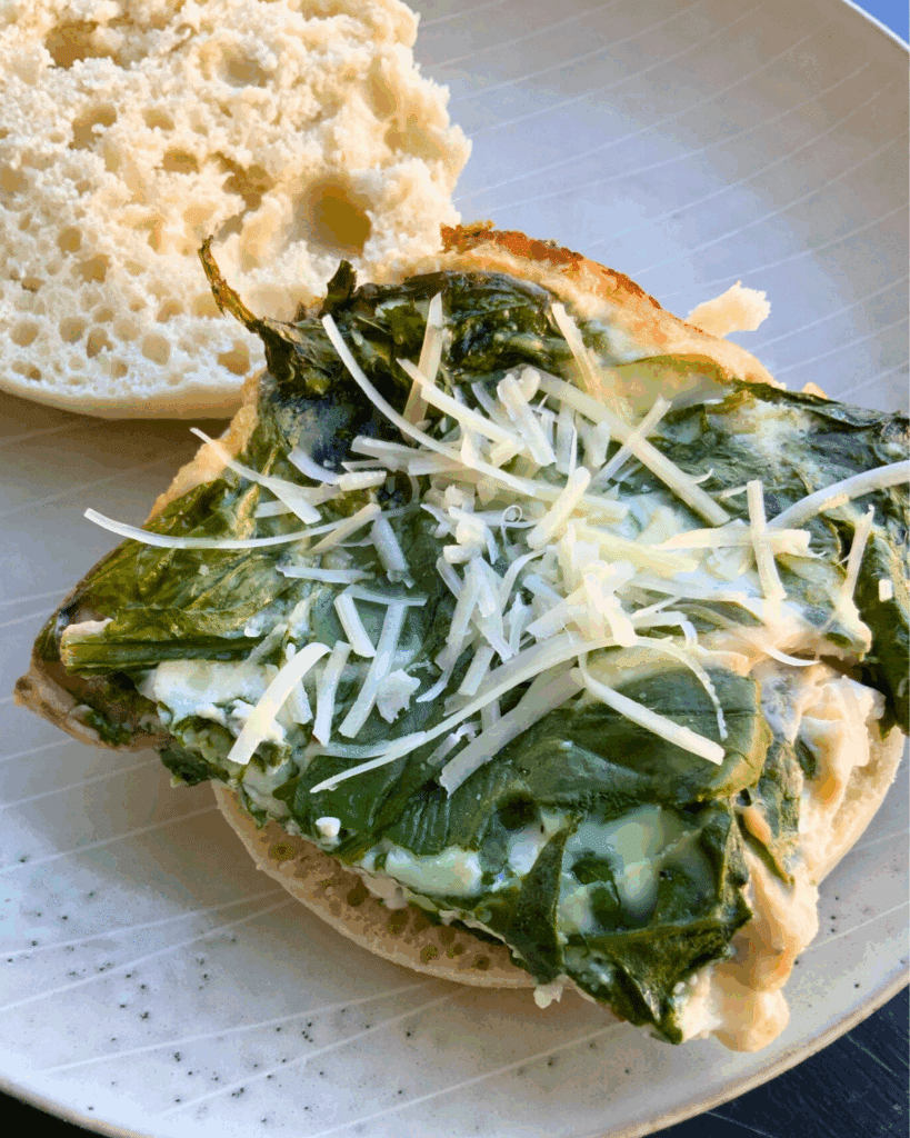 Egg sandwich on English Muffin with spinach made in slow cooker on a plate