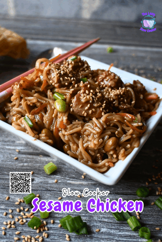 A square white bowl filled with sesame chicken and noodles, topped with sesame seeds and green onions, sits on a wooden table with chopsticks and a roll in the background. Slow Cooker Sesame Chicken is written on the image.