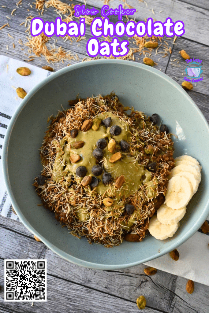 A blue bowl of oatmeal with kataifi, chocolate chips, nuts, nut butter, and banana slices on a striped cloth atop a wood table.