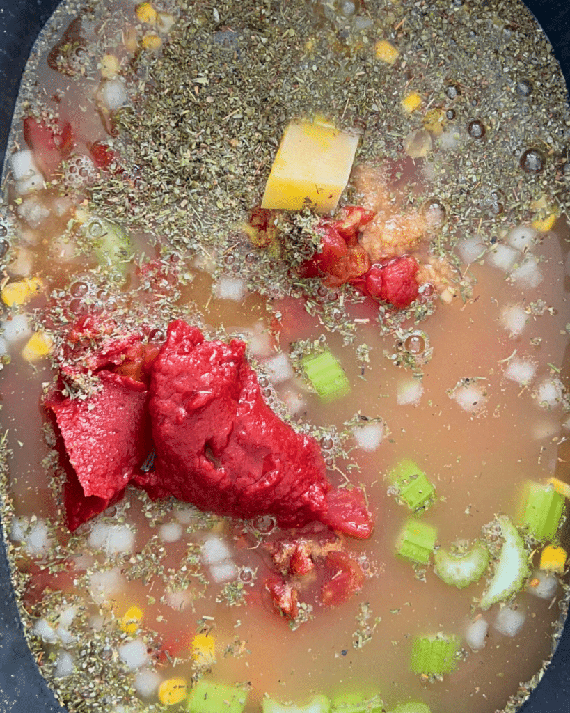 close up of tuscan chicken vegetable soup ingredients in a a slow cooker before cooking